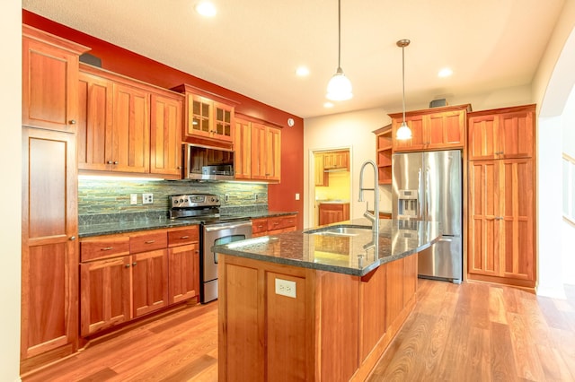 10725 Toledo Ln N, Brooklyn Park, MN 55443 - kitchen featuring appliances with stainless steel finishes, light wood-style floors, tasteful backsplash, a center island with sink, and recessed lighting