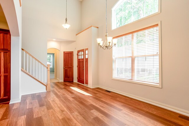 10725 Toledo Ln N, Brooklyn Park, MN 55443 - foyer entrance featuring arched walkways, stairway, wood finished floors, plenty of natural light, and a high ceiling