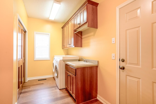 10725 Toledo Ln N, Brooklyn Park, MN 55443 - laundry room featuring cabinet space, independent washer and dryer, light wood finished floors, and a textured ceiling