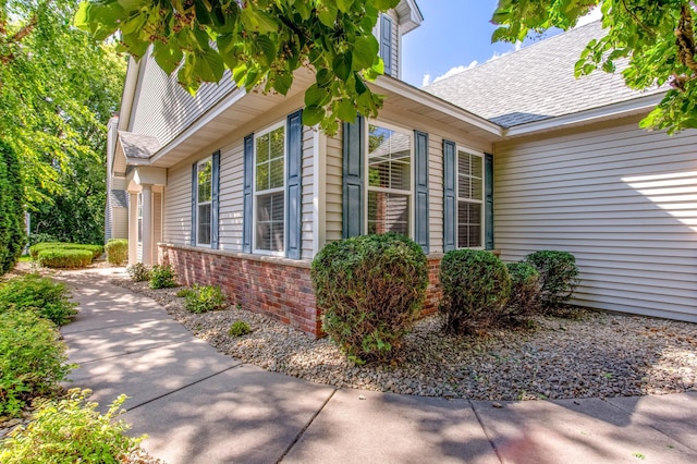 10725 Toledo Ln N, Brooklyn Park, MN 55443 - view of property exterior with a shingled roof and brick siding