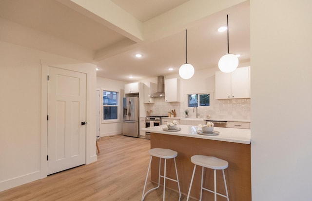212 Diamond Lake Rd, Minneapolis, MN 55419 - kitchen with wall chimney exhaust hood, stainless steel appliances, a breakfast bar area, white cabinetry, and light wood-type flooring