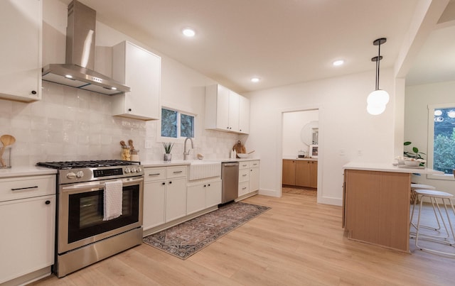 212 Diamond Lake Rd, Minneapolis, MN 55419 - kitchen featuring appliances with stainless steel finishes, wall chimney range hood, light wood finished floors, light countertops, and recessed lighting