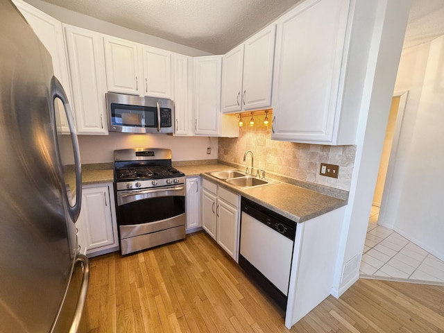 220 Mackubin St Unit 220, Saint Paul, MN 55102 - kitchen with appliances with stainless steel finishes, light wood-type flooring, white cabinetry, tasteful backsplash, and a textured ceiling