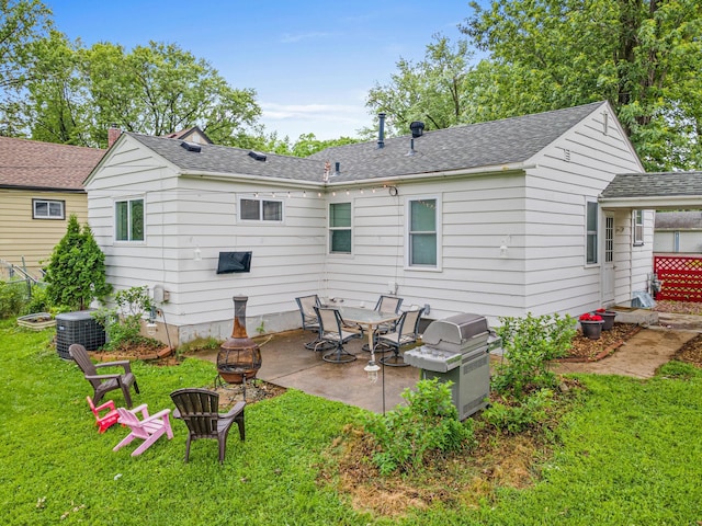 8313 Stevens Ave S, Bloomington, MN 55420 - rear view of house with an outdoor fire pit, a patio area, a lawn, and a shingled roof