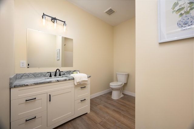 half bathroom featuring wood finished floors and vanity