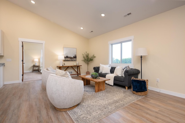 living room with light wood-style floors, recessed lighting, and vaulted ceiling