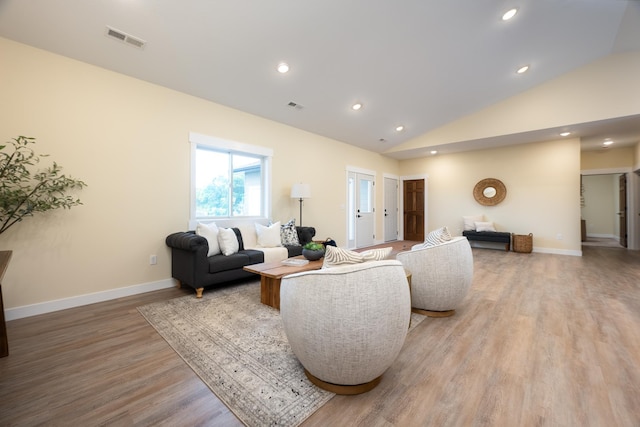 living area featuring light wood finished floors, vaulted ceiling, and recessed lighting