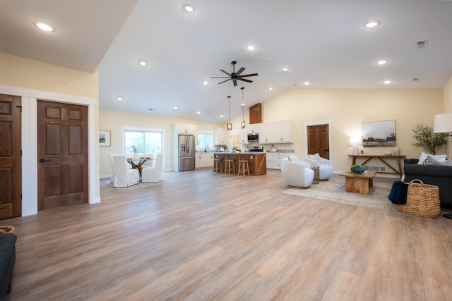 living room featuring ceiling fan, recessed lighting, light wood finished floors, and high vaulted ceiling