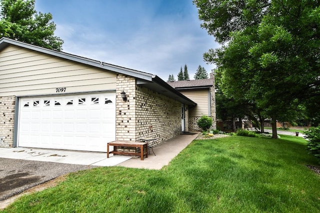 7097 Robinwood Bay, Woodbury, MN 55125 - view of home's exterior featuring brick siding, a garage, and a yard