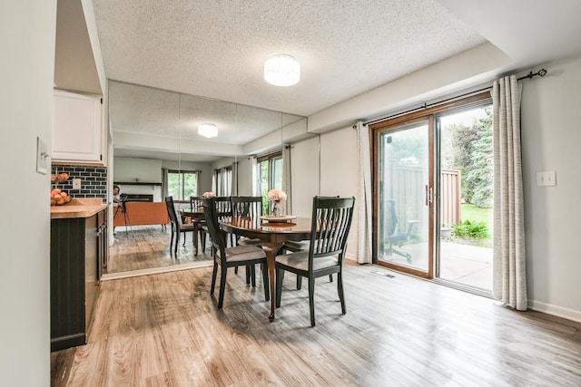 7097 Robinwood Bay, Woodbury, MN 55125 - dining area with light wood-style flooring and a textured ceiling