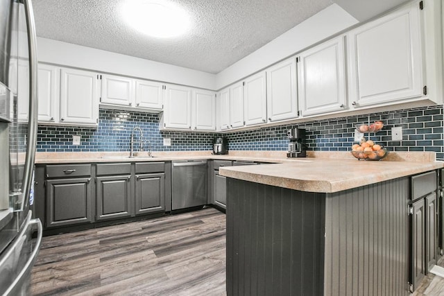 7097 Robinwood Bay, Woodbury, MN 55125 - kitchen featuring stainless steel appliances, gray cabinetry, a textured ceiling, white cabinets, and wood finished floors