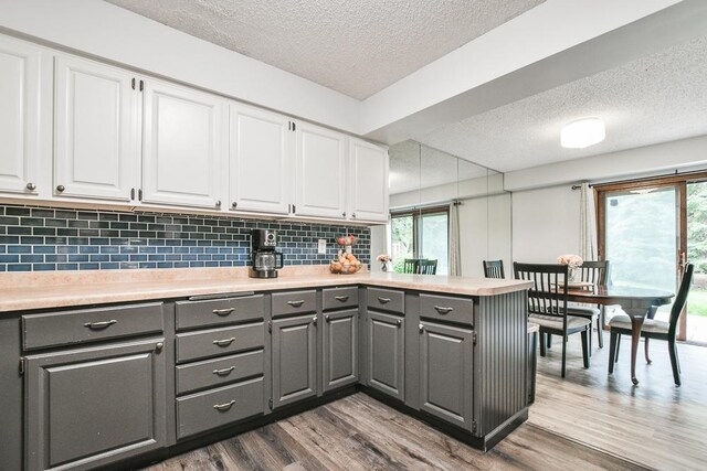 7097 Robinwood Bay, Woodbury, MN 55125 - kitchen featuring gray cabinetry, a textured ceiling, white cabinets, and a peninsula