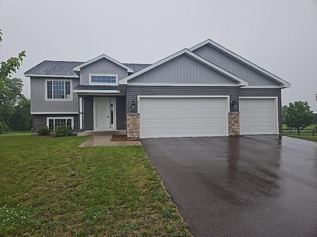 591 Alaska Loop, Cambridge, MN 55008 - view of front of house with asphalt driveway, an attached garage, a front lawn, a shingled roof, and stone siding