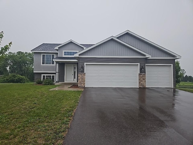 591 Alaska Loop, Cambridge, MN 55008 - view of front facade featuring asphalt driveway, a garage, a front yard, and stone siding