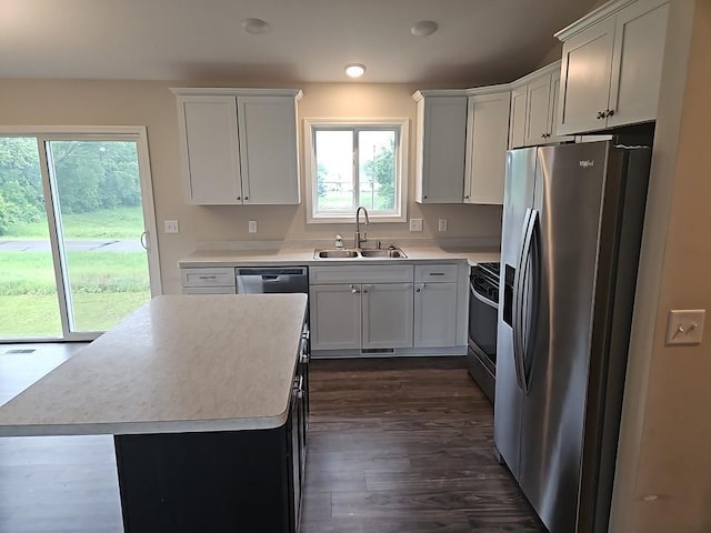 591 Alaska Loop, Cambridge, MN 55008 - kitchen with stainless steel appliances, light countertops, dark wood-style flooring, a kitchen island, and white cabinetry