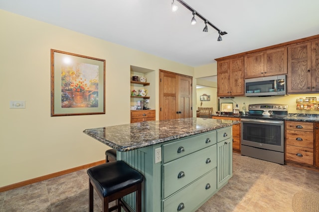 23148 Glenhaven Dr, Nevis, MN 56467 - kitchen with stainless steel appliances, green cabinetry, a kitchen island, track lighting, and a kitchen breakfast bar