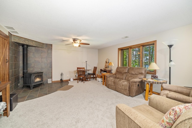 23148 Glenhaven Dr, Nevis, MN 56467 - living room featuring a wood stove, ceiling fan, and carpet