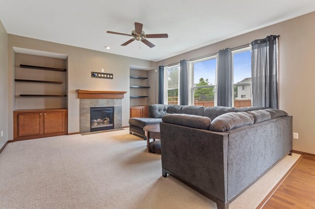 17393 54th St NE, Otsego, MN 55374 - living area with built in shelves, a ceiling fan, and a tile fireplace