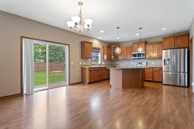 17393 54th St NE, Otsego, MN 55374 - kitchen with appliances with stainless steel finishes, brown cabinets, dark wood finished floors, a chandelier, and glass insert cabinets