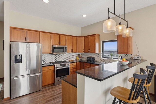 270 4th St E Unit 509, Saint Paul, MN 55101 - kitchen with stainless steel appliances, a peninsula, brown cabinets, dark wood-style floors, and recessed lighting