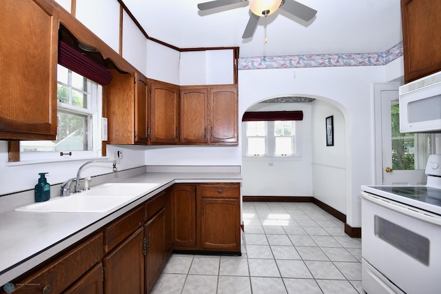 1321 4th St N, Fargo, ND 58102 - kitchen featuring white appliances, arched walkways, light countertops, ceiling fan, and light tile patterned floors