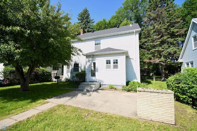 1321 4th St N, Fargo, ND 58102 - rear view of house featuring a yard, a chimney, and a patio