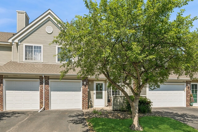 8829 Branson Dr Unit 46, Inver Grove Heights, MN 55076 - view of front of property with driveway, brick siding, roof with shingles, and a garage