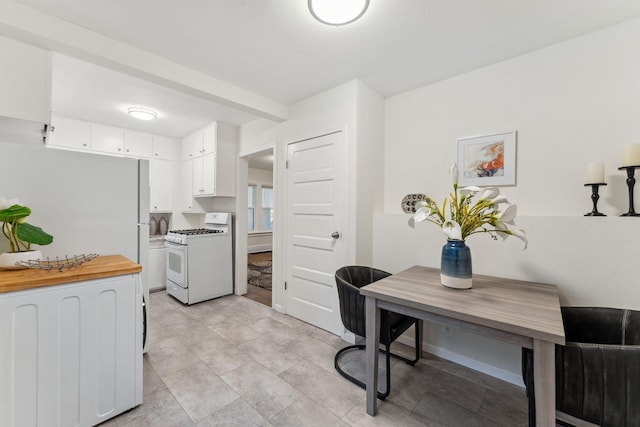 4714 Aldrich Ave N, Minneapolis, MN 55430 - kitchen with white gas range, white cabinetry, and wooden counters