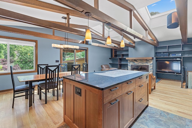 1803 Hubbard Ave, Saint Paul, MN 55104 - kitchen with a skylight, dark countertops, a center island, hanging light fixtures, and brown cabinets