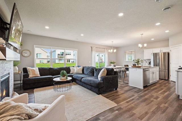 9266 26th St NE, Saint Michael, MN 55376 - living room featuring a chandelier, a glass covered fireplace, healthy amount of natural light, dark wood-style floors, and recessed lighting