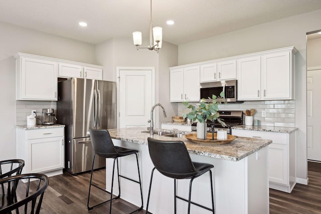 9266 26th St NE, Saint Michael, MN 55376 - kitchen featuring appliances with stainless steel finishes, dark wood-type flooring, decorative backsplash, white cabinetry, and recessed lighting