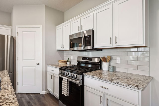 9266 26th St NE, Saint Michael, MN 55376 - kitchen featuring appliances with stainless steel finishes, dark wood-style flooring, white cabinetry, and backsplash