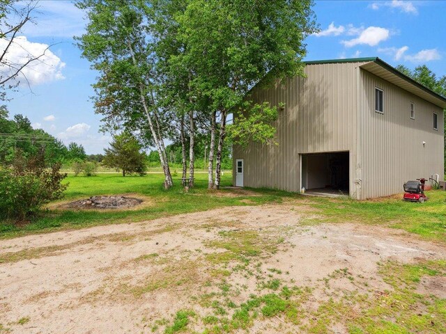 25935 310th St, Sebeka, MN 56477 - view of yard featuring a garage, driveway, an outdoor structure, and an outbuilding