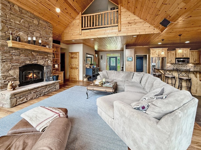 49512 202nd Pl, Shamrock Twp, MN 55760 - living room featuring wooden ceiling, wood finished floors, high vaulted ceiling, a stone fireplace, and recessed lighting