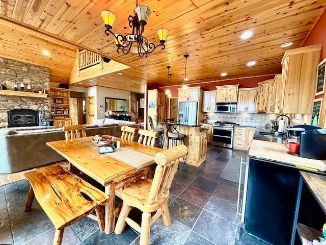 49512 202nd Pl, Shamrock Twp, MN 55760 - dining space featuring wooden ceiling, a chandelier, stone tile floors, a stone fireplace, and recessed lighting