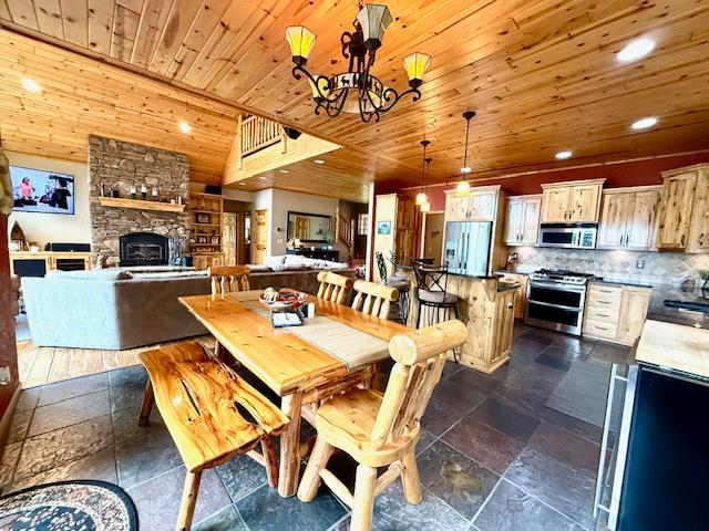 49512 202nd Pl, Shamrock Twp, MN 55760 - dining room with wooden ceiling, a chandelier, stone tile floors, recessed lighting, and a fireplace