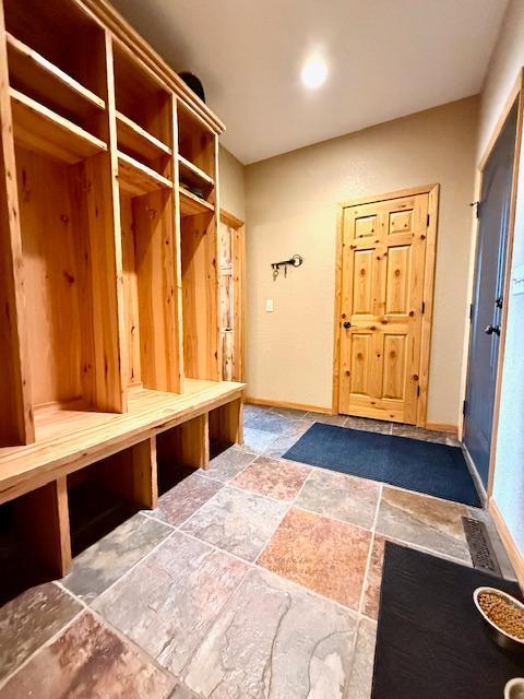 49512 202nd Pl, Shamrock Twp, MN 55760 - mudroom featuring stone tile floors and baseboards