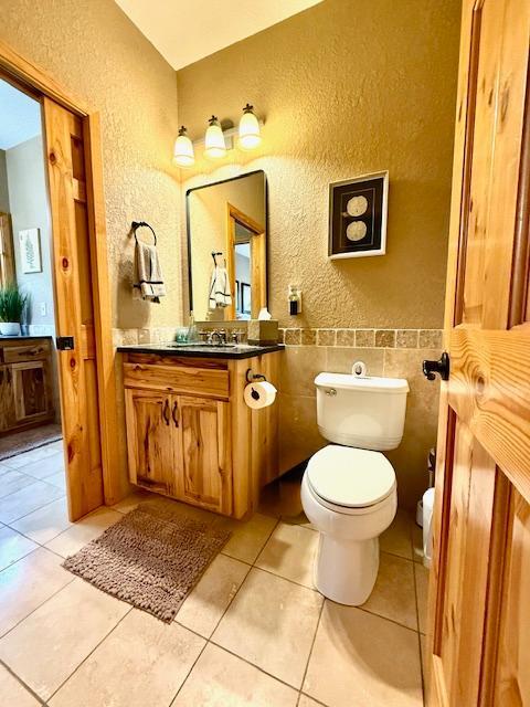 49512 202nd Pl, Shamrock Twp, MN 55760 - bathroom featuring a textured wall, vanity, and tile patterned flooring