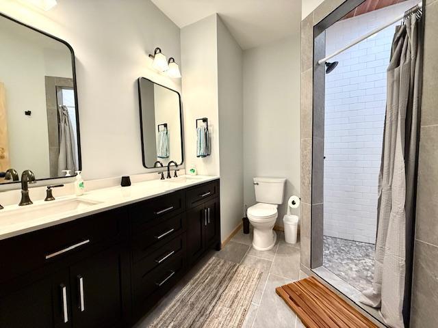 49512 202nd Pl, Shamrock Twp, MN 55760 - bathroom with double vanity, tiled shower, and tile patterned flooring