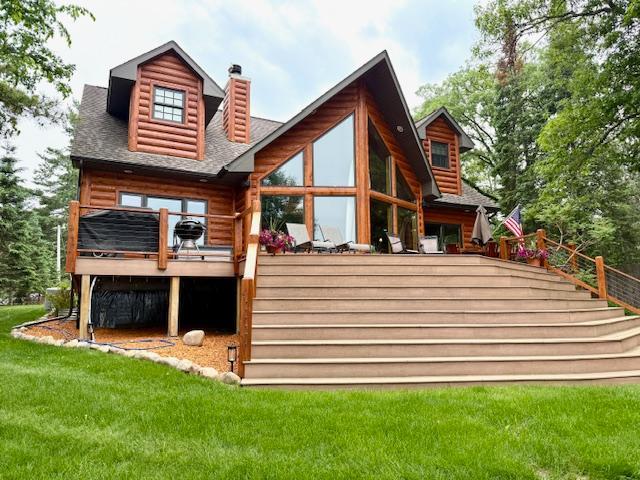 49512 202nd Pl, Shamrock Twp, MN 55760 - rear view of house with a chimney, a deck, and a lawn