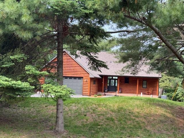 49512 202nd Pl, Shamrock Twp, MN 55760 - log-style house with log veneer siding, covered porch, a front lawn, and a garage