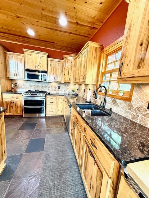 49512 202nd Pl, Shamrock Twp, MN 55760 - kitchen featuring appliances with stainless steel finishes, wood ceiling, dark stone countertops, tasteful backsplash, and dark stone finish floors