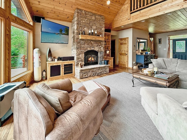 49512 202nd Pl, Shamrock Twp, MN 55760 - living area featuring wood ceiling, wood finished floors, high vaulted ceiling, a stone fireplace, and wooden walls