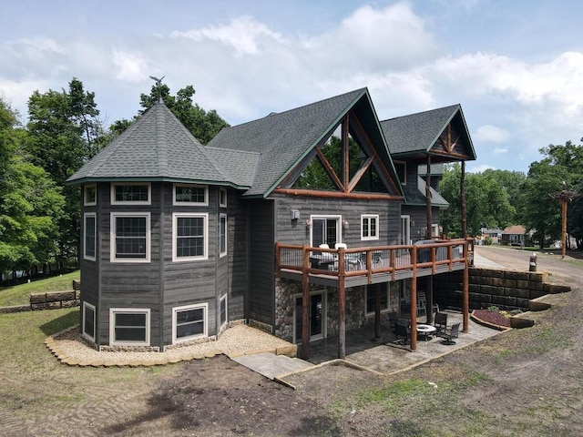 2406 Augusta Rd, Fair Haven Twp, MN 55382 - rear view of property featuring a deck, a patio area, roof with shingles, and stone siding