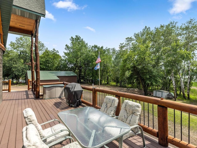 2406 Augusta Rd, Fair Haven Twp, MN 55382 - deck with a storage unit, a jacuzzi, a grill, and view of scattered trees