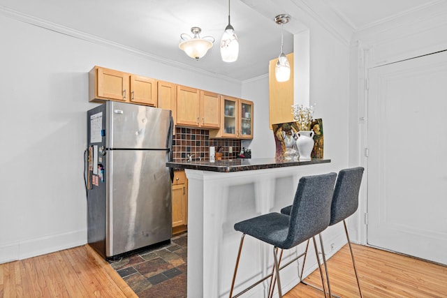 1820 1st Ave S Unit 208, Minneapolis, MN 55403 - kitchen featuring freestanding refrigerator, a breakfast bar area, dark countertops, tasteful backsplash, and glass insert cabinets