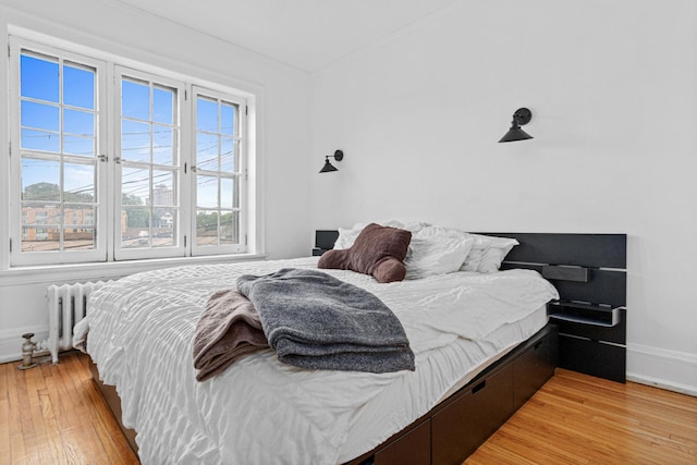 1820 1st Ave S Unit 208, Minneapolis, MN 55403 - bedroom featuring radiator and light wood finished floors