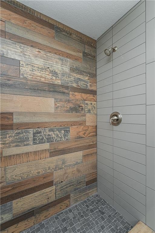 2105 Elk Run Dr SE, Pine Island, MN 55963 - full bath with wooden walls, tiled shower, and a textured ceiling