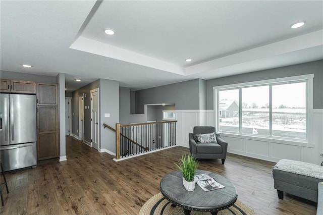 2105 Elk Run Dr SE, Pine Island, MN 55963 - sitting room with an upstairs landing, dark wood-style floors, a tray ceiling, recessed lighting, and a wainscoted wall