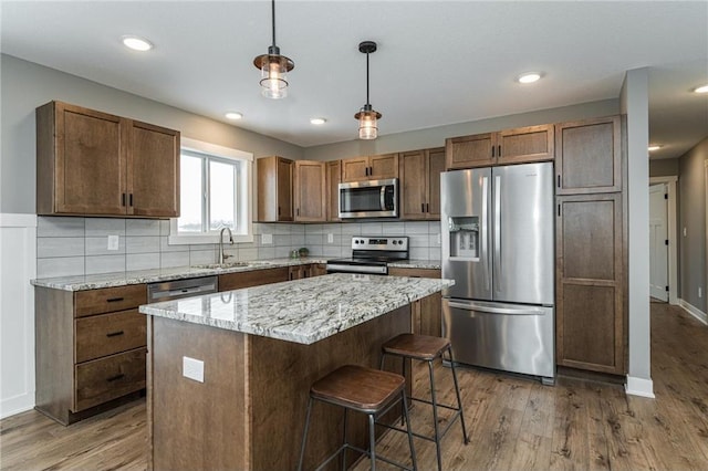 2105 Elk Run Dr SE, Pine Island, MN 55963 - kitchen with appliances with stainless steel finishes, wood finished floors, tasteful backsplash, and recessed lighting